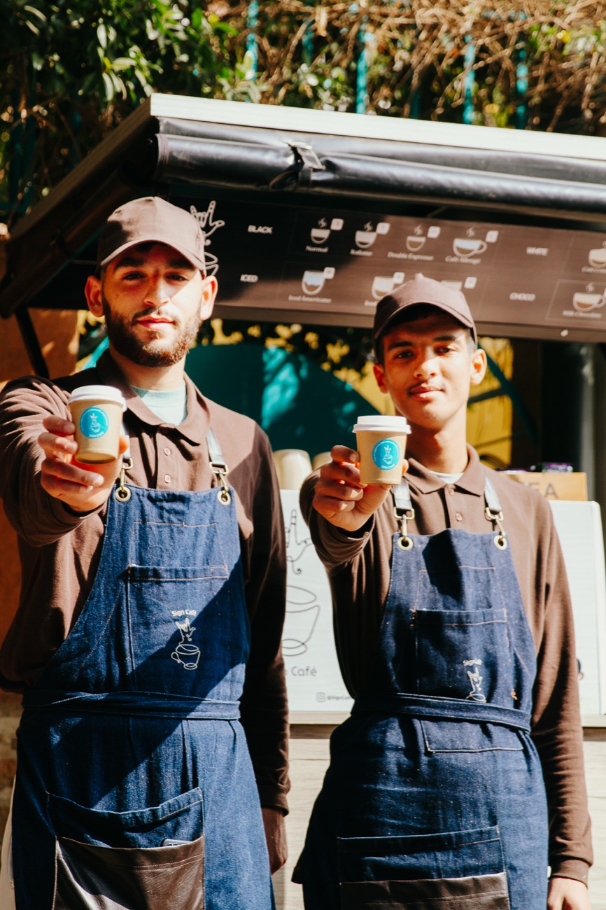 Two Amal baristas at the Sign Café Coffee Bike